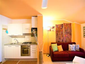 a living room with a couch and a kitchen at Apartment Arco Climbing in Arco