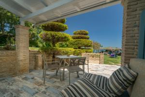 a patio with a table and chairs on a patio at Fiore Beach Studios in Vasilikos