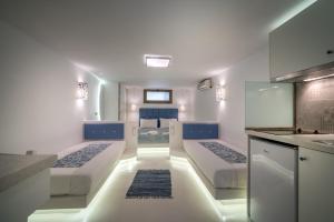 a bedroom with two beds and a kitchen with a counter at Fiore Beach Studios in Vasilikos
