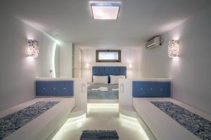 two beds in a white room with a bedroom at Fiore Beach Studios in Vasilikos
