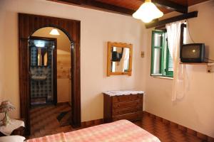 a bedroom with a bed and a television and a mirror at Eleonora in Chania Town