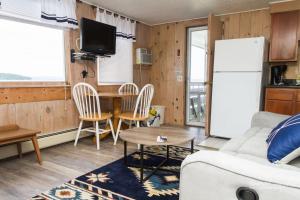 a living room with a table and a refrigerator at Belknap Point Inn in Gilford