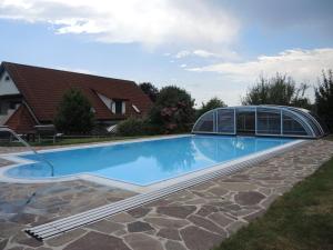 a swimming pool with a glass house at Landhaus Dampf in Bad Blumau