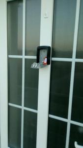 a glass door with a metal latch on it at Apartman Mm in Slavonski Brod