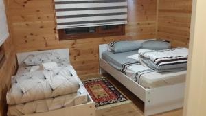 アイダー・ヤイラシにあるAYDER ŞAFAK Apartのベッド2台と布団が備わる客室です。