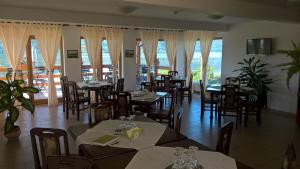 a dining room with tables and chairs and windows at Villa Rustica in Gornea