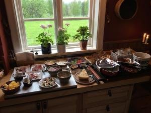 Knappgården في سارنا: طاولة مليئة بالطعام على منضدة مع نافذة