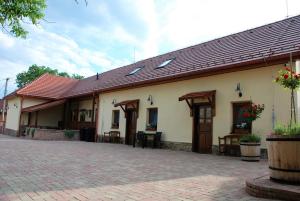 ein Gebäude mit einem roten Dach und einer Terrasse in der Unterkunft Ubytovanie Tri ruže in Krásnohorské Podhradie