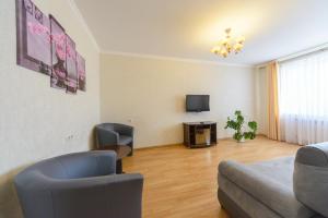 キーウにあるARTAL Apartment on Obolonskaya Square 3のリビングルーム(ソファ、椅子、テレビ付)
