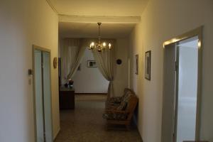 un couloir avec une chaise et un lustre dans l'établissement La casa dei nonni, à Tassullo 12 autres photos