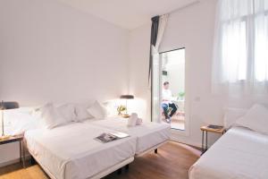 a hotel room with two beds and a window at Som Nit Triomf in Barcelona