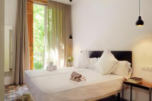 a bedroom with a large white bed with a window at Som Nit Triomf in Barcelona