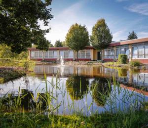 an office building with a pond in front of it at Wunderland Kalkar in Kalkar