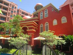 a red building with trees in front of some buildings at Seven Seas 410 in Jomtien Beach