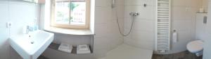 łazienka z umywalką, toaletą i oknem w obiekcie Pension Alter Wirt w mieście Enkering