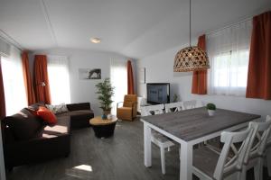 uma sala de estar com uma mesa e um sofá em IJsselmeer-chalet nr. 66 em Molkwerum