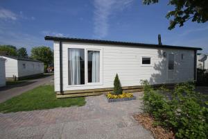 um pequeno edifício branco com uma janela em IJsselmeer-chalet nr. 66 em Molkwerum