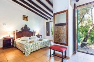 
a bedroom with a bed, chair, table and window at Agroturisme Ca'n Gaia in Portocolom
