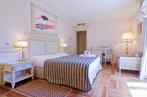 A bed or beds in a room at Hotel De Paris Sanremo