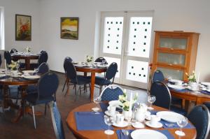Hotel B8 Voerde في Voerde: غرفة طعام مع طاولات وكراسي في غرفة