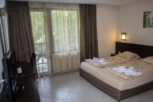 Family Hotel Delta في أوجنيانوفو: غرفة فندق بها سرير ومناشف عليه +65 صورة