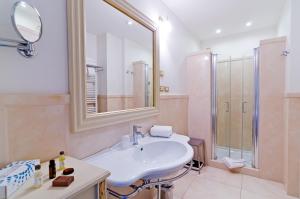 a bathroom with a sink, mirror, and bathtub at Hotel De Paris Sanremo in Sanremo