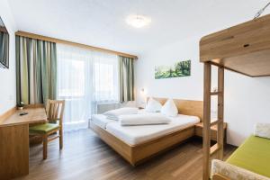 Pokój hotelowy z łóżkiem i biurkiem w obiekcie Gasthof Venedigerblick w mieście Neukirchen am Großvenediger
