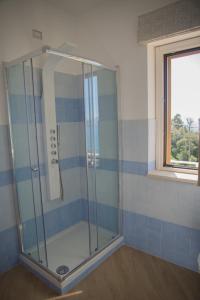 a glass shower in a bathroom with a window at Villa Caterina Affittacamere in Maratea