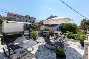 a patio with a table and chairs and an umbrella at Villa Sarah in Supetar