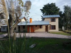 ein Haus mit einer Palme davor in der Unterkunft El Alamo in Sierra de la Ventana