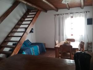Zimmer mit einer Treppe, einem Tisch und einem Bett in der Unterkunft El Alamo in Sierra de la Ventana