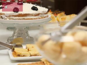 a table with a cake and a plate of desserts at Hotel Gaucha in Guaíra