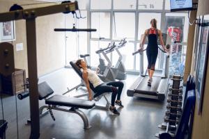Dos mujeres en el gimnasio en cintas de correr y una mujer caminando en Land Plaza Hotel, en Bahía Blanca
