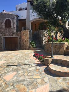 un patio de piedra frente a una casa en I Mari Di Gallura Suites and Rooms, en San Teodoro