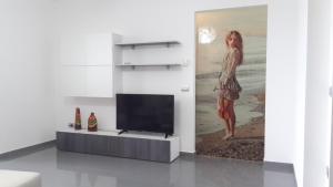 a living room with a television and a painting of a woman at residence Giulia in Torre Melissa