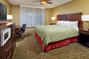 um quarto de hotel com uma cama e uma televisão de ecrã plano em Sands by the Sea Motel em San Simeon