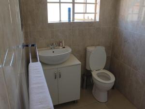 a bathroom with a toilet and a sink at Divine Guest Lodge in Rustenburg