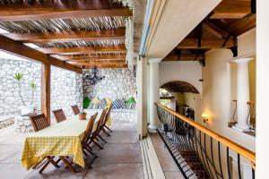 a patio with a table and chairs and a stone wall at Villa Pescatori in Yzerfontein