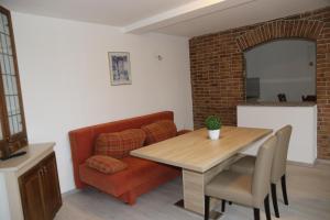 uma sala de estar com uma mesa e um sofá em Apartmani Villa Christina em Ičići