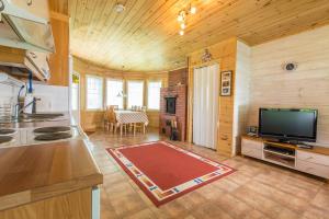 a kitchen with a television and a living room with a table at Resort Naaranlahti Cottages in Naaranlahti