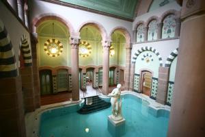 Una piscina en un edificio con una estatua. en Atina Hotel, en Bad Wildbad