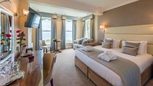 um quarto de hotel com uma cama grande e uma televisão em The Carlyon Bay Hotel and Spa em St Austell