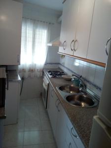 a kitchen with a sink and a stove at Apartamento Con Parking Gratuito in Granada