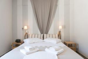 Aeolos Apartments في كاماراي: غرفة نوم بسرير ابيض عليها مناشف
