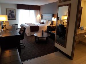 a hotel room with a bed and a desk at Northbury Hotel and Conference Centre in Sudbury