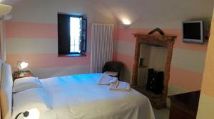 a bedroom with a bed and a mirror and a television at Archisa Relais Hostaria in Farigliano