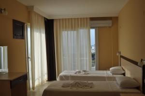a hotel room with two beds and a window at Blue Sea Hotel & Spa in Kuşadası