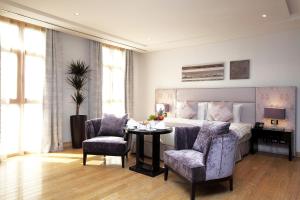 فلل فيفيندا الفندقية غرناطة في الرياض: غرفة نوم بسرير وطاولة وكراسي