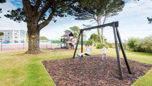 
a child is playing in a park on a sunny day at The Carlyon Bay Hotel and Spa in St Austell
