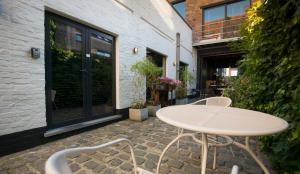- une table et des chaises blanches sur la terrasse dans l'établissement Gastenkamers UitGaanSlapen, à Nieuport